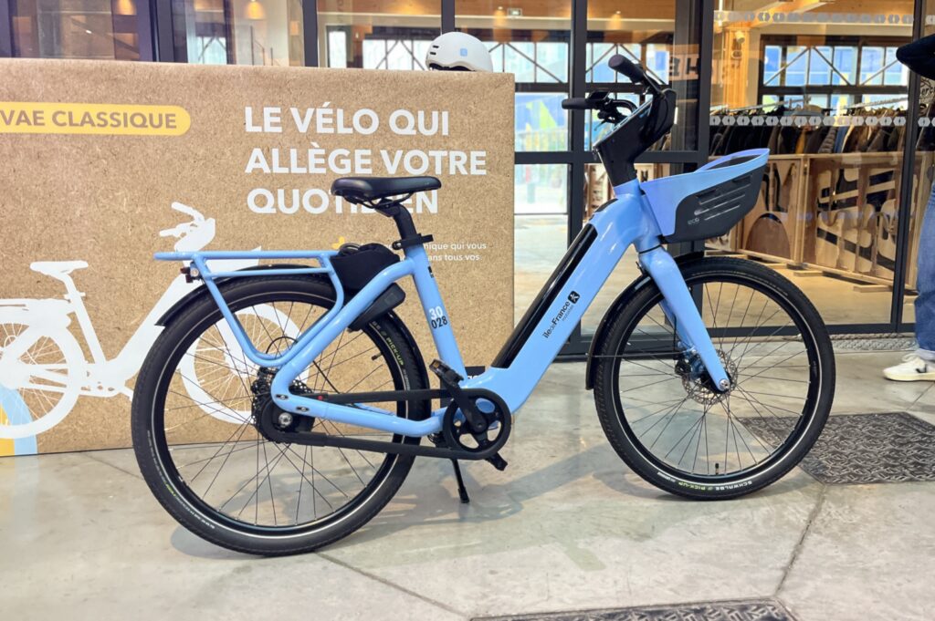 Un vélo à assistance électrique assez imposant avec ses porte-bagages massifs et sa batterie dans le cadre.